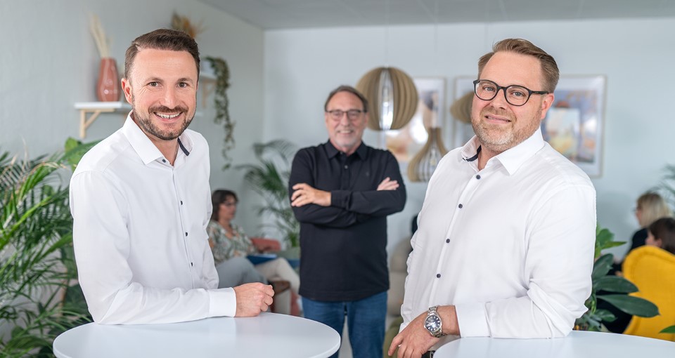 Die neuen Geschäftsführer Johannes-Falco Kreienbaum und Stephan Berlemann stehen im Vordergrund, im Hintergrund ist Frank-Eugen Kreienbaum (alter Geschäftsführer) zu sehen.